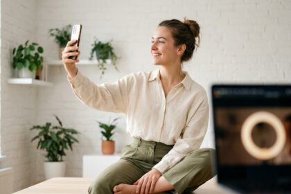 Influenceuse enregistrant une vidéo sur smartphone dans un studio home office minimaliste pour une campagne de notoriété de marque